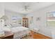 Bright bedroom featuring white wood paneling, wood floors, and a comfortable bed at 12404 Sunshine Ln, Treasure Island, FL 33706