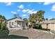 This home features a covered front porch, a carport, and gravel landscaping at 12404 Sunshine Ln, Treasure Island, FL 33706
