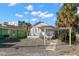 Charming single-story home featuring a welcoming porch, a carport, and tropical landscaping at 12404 Sunshine Ln, Treasure Island, FL 33706