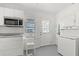 Galley kitchen has white cabinets, stainless appliances, and exterior door for easy access at 12404 Sunshine Ln, Treasure Island, FL 33706
