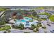 Aerial view featuring a community center, pool, and tennis courts surrounded by green spaces and parking at 12427 Bay Estuary Bnd, Riverview, FL 33579