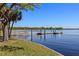 Waterfront view with wooden deck and pier where the lake meets the shoreline at 14 Cypress Dr, Palm Harbor, FL 34684