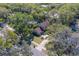 Aerial view of a charming home surrounded by lush greenery, featuring a well-manicured lawn and inviting curb appeal at 1439 Wetherington Way, Palm Harbor, FL 34683
