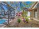 Lush backyard with a serene garden and partial view of the screened in pool area at 1439 Wetherington Way, Palm Harbor, FL 34683
