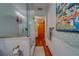 Bright bathroom showcasing a glass-enclosed shower, unique wallpaper, and hardwood floors at 1439 Wetherington Way, Palm Harbor, FL 34683