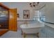 Elegant bathroom featuring a clawfoot tub, white tile, and vintage-style fixtures, exuding charm and sophistication at 1439 Wetherington Way, Palm Harbor, FL 34683