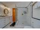 Bright bathroom featuring a glass-enclosed shower, vanity, and unique tile flooring at 1439 Wetherington Way, Palm Harbor, FL 34683