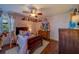 Quaint bedroom with soft pink walls, wood floors, and a ceiling fan, offering a cozy and personalized space at 1439 Wetherington Way, Palm Harbor, FL 34683