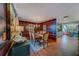A dining room is presented with wood floors, plaid wallpaper, and a wooden table set for six with decorative chairs at 1439 Wetherington Way, Palm Harbor, FL 34683