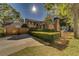 Traditional home with a well-manicured lawn, mature trees, and a driveway leading to a two-car garage at 1439 Wetherington Way, Palm Harbor, FL 34683