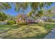 Picturesque home with a large front lawn, mature trees, and classic architectural features at 1439 Wetherington Way, Palm Harbor, FL 34683