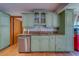 Well-maintained kitchen featuring sage cabinets, granite countertops, stainless steel appliances and wood-look floors at 1439 Wetherington Way, Palm Harbor, FL 34683