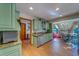 Inviting kitchen featuring vintage green cabinetry, stainless steel appliances, granite countertops, and wood-look tile flooring at 1439 Wetherington Way, Palm Harbor, FL 34683