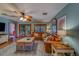 Spacious living room featuring a large leather sofa, ceiling fan and sliding glass doors to patio at 1439 Wetherington Way, Palm Harbor, FL 34683