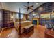 A luxurious bedroom with a four poster bed, fireplace, and unique plaid wallpaper at 1439 Wetherington Way, Palm Harbor, FL 34683