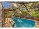 Bright and inviting screened-in pool area with ample sunshine, pavers and lush landscaping at 1439 Wetherington Way, Palm Harbor, FL 34683