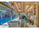Inviting pool patio with comfortable seating, ceiling fan, and lush greenery surrounding the pool at 1439 Wetherington Way, Palm Harbor, FL 34683