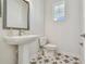 Quaint powder room featuring a pedestal sink, patterned floor tiles, and neutral paint color at 1558 Merrythought Ln, Sarasota, FL 34240