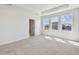 Large bedroom with tray ceiling, neutral carpet, and three large windows providing ample natural light at 1558 Merrythought Ln, Sarasota, FL 34240