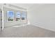 Bright bedroom featuring neutral carpet, lots of light from three large windows, and white walls at 1558 Merrythought Ln, Sarasota, FL 34240