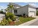 Exterior of home with garage, landscaping, bushes, palm trees, and blue sky at 1558 Merrythought Ln, Sarasota, FL 34240