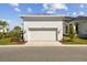 Detached one car garage with white siding and roof, featuring a paved driveway and manicured landscaping at 1558 Merrythought Ln, Sarasota, FL 34240