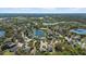 Wide aerial view of a neighborhood with lakes and surrounding woods at 15616 Greyrock Dr, Spring Hill, FL 34610