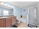 Well-lit bathroom with a vanity, soaking tub, and glass-enclosed shower stall at 15616 Greyrock Dr, Spring Hill, FL 34610