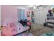 A cozy bedroom with pink walls, carpet, ceiling fan, and a double door closet at 15616 Greyrock Dr, Spring Hill, FL 34610