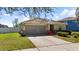 Well-manicured lawn and landscape accent the front of this single-story home with a two car garage at 15616 Greyrock Dr, Spring Hill, FL 34610