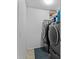 A laundry room with a washer and dryer with a blue rug on the tile floors at 15616 Greyrock Dr, Spring Hill, FL 34610