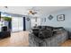 Open-concept living room with a large sofa, sliding glass door, and a ceiling fan at 15616 Greyrock Dr, Spring Hill, FL 34610