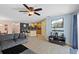 The comfortable living space is connected with an island kitchen and a dining area, all under a ceiling fan at 15616 Greyrock Dr, Spring Hill, FL 34610
