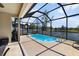 Enjoy the screened-in pool and patio overlooking the lake in this home's private backyard at 15616 Greyrock Dr, Spring Hill, FL 34610