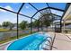 Screened in-ground pool with sunny patio and view of the backyard at 15616 Greyrock Dr, Spring Hill, FL 34610