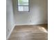 Neat bedroom with a view from the window, clean baseboards, and light-colored wood flooring at 1606 Marilyn Ave, Bradenton, FL 34207