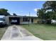 Charming single-story home with a well-maintained lawn and covered parking in a suburban neighborhood at 1606 Marilyn Ave, Bradenton, FL 34207
