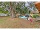 Large backyard featuring mature trees, patio area, and ample space for outdoor activities at 1617 Cherokee Trl, Valrico, FL 33594