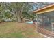 Spacious backyard with mature trees, a deck area, and a screened-in porch at 1617 Cherokee Trl, Valrico, FL 33594