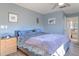 Cozy bedroom features a queen-size bed, wood floors, ceiling fan and soothing blue walls, creating a peaceful retreat at 1617 Cherokee Trl, Valrico, FL 33594