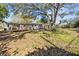 Spacious backyard with a wooden deck, mature trees, and plenty of room for outdoor activities at 1653 S Prescott Ave, Clearwater, FL 33756