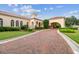 Elegant building with arched entryway and brick driveway, nestled in lush landscaping and manicured lawns at 17005 Madres De Avila, Tampa, FL 33613