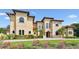 Beautiful Mediterranean-style home boasting a tile roof, arched windows, and meticulously maintained landscaping at 17005 Madres De Avila, Tampa, FL 33613