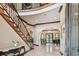Elegant foyer featuring marble floors, a curved staircase with iron railings, and a view into a formal living area at 17005 Madres De Avila, Tampa, FL 33613