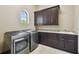 Laundry room with a washer, dryer, dark cabinets, granite counters and a sink at 17005 Madres De Avila, Tampa, FL 33613