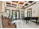 Formal living room with marble floors, a piano, and views of the pool through French doors at 17005 Madres De Avila, Tampa, FL 33613