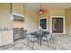 Outdoor dining area with barbecue, table and chairs and a covered patio at 17005 Madres De Avila, Tampa, FL 33613