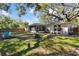 Spacious backyard with mature trees, featuring a charming screened patio and outdoor seating, perfect for enjoying nature at 1887 Oak Forest E Dr, Clearwater, FL 33759