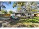 A view of the fenced yard featuring mature trees, outdoor seating, and an enclosed patio, inviting outdoor relaxation at 1887 Oak Forest E Dr, Clearwater, FL 33759