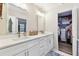 Bathroom featuring dual sinks with white cabinetry and adjacent walk-in closet at 1887 Oak Forest E Dr, Clearwater, FL 33759